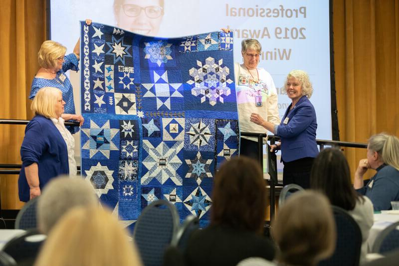 women surrounding quilt